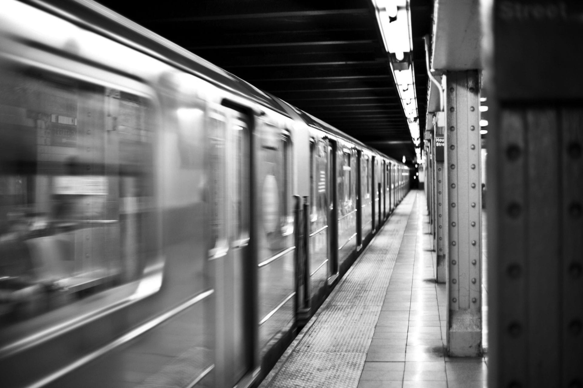 A train is traveling down the tracks in a station.