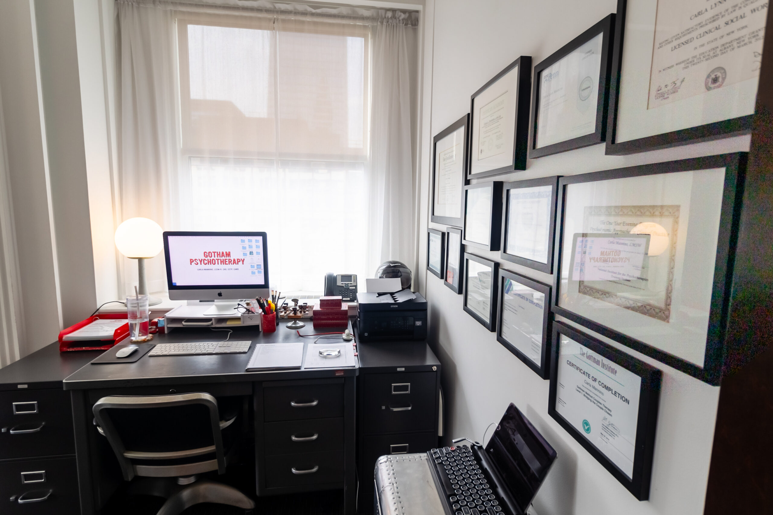 A room with many pictures on the wall and a desk