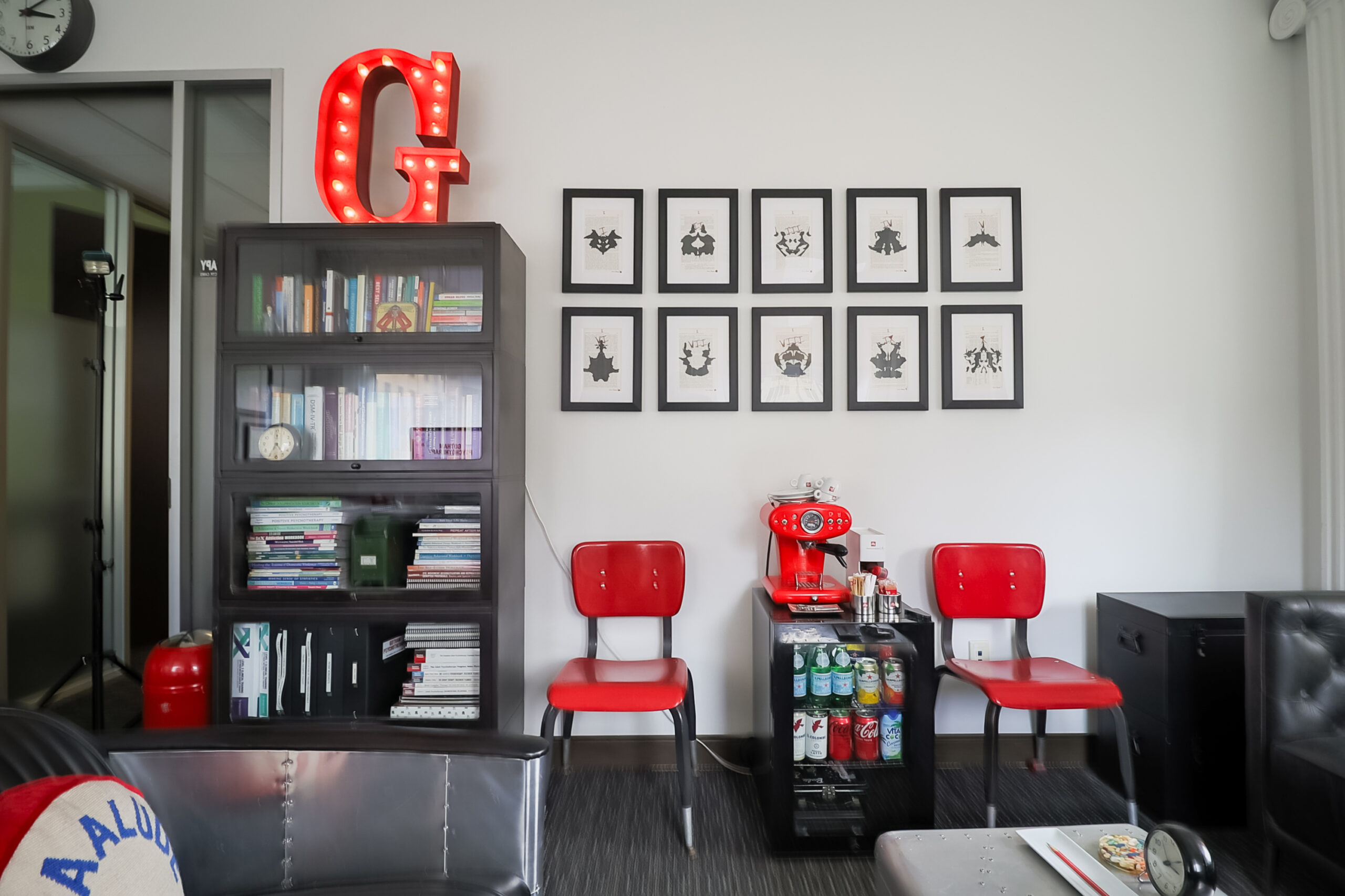 A room with red chairs and black bookcases